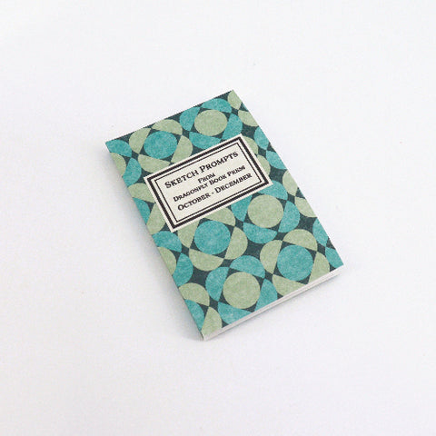Notebook with green and blue geometric pattern on a white background
